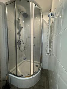 a shower with a glass door in a bathroom at Apartamenty Dworcowe Stacja Centrum Kielce in Kielce