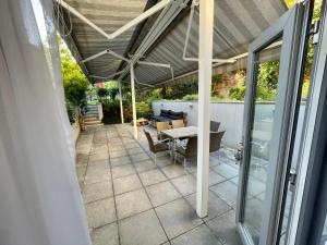 eine Terrasse mit Markise sowie einem Tisch und Stühlen in der Unterkunft Pension Phoenix in Znojmo