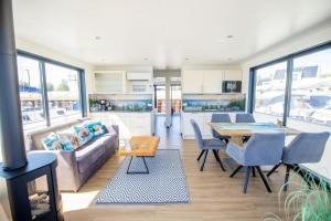 a kitchen and living room with a couch and a table at Hausboot Träumerei - LP3 in Peenemünde