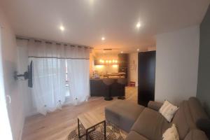 una sala de estar con un sofá y una mesa en Magnifique T2 meublé au pied du port, en Capbreton