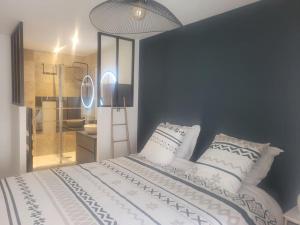 Un dormitorio con una cama blanca con almohadas y una luz. en Magnifique T2 meublé au pied du port, en Capbreton