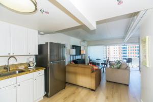 Il comprend un salon et une cuisine équipée d'un réfrigérateur en acier inoxydable. dans l'établissement Ilikai Tower 1642 Lagoon View 1BR, à Honolulu