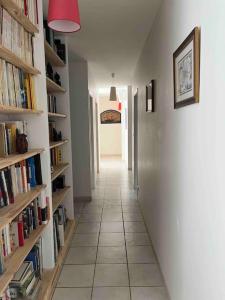 a hallway with bookshelves and a hallway with a hallway sidx sidx at Maison de famille avec clim, piscine et parking in Nîmes