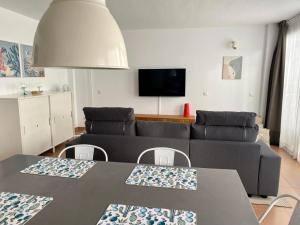 een woonkamer met een bank en een tafel bij vista oceano, confortevole, ampio, gran terrazza, Wi-Fi in Costa Calma