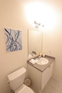 a bathroom with a white toilet and a sink at Luxurious Condo Apartment 2BRs-1BAs-1Office with free parking in Brampton +23 photos