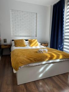 a bedroom with a bed with two slippers on it at Apartamenty Dworcowe Stacja Centrum Kielce in Kielce