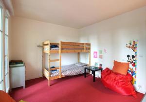 1 dormitorio con litera y alfombra roja en Bel appartement situé face à la Vallée Shopping à quelques minutes de Disney, en Serris