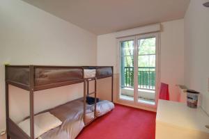 1 dormitorio con 2 literas y ventana en Bel appartement situé face à la Vallée Shopping à quelques minutes de Disney, en Serris