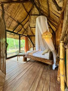 a bedroom with a bed in a thatched room at Akasha suites in Doradal