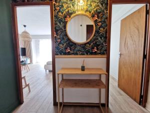 - un miroir et une table dans la chambre dans l'établissement Appart'Cosy - clim - terrasse - ascenseur, à Cavaillon