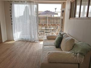 - un salon avec un canapé et une table avec un parasol dans l'établissement Appart'Cosy - clim - terrasse - ascenseur, à Cavaillon