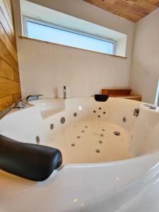 eine Badewanne im Bad mit Fenster in der Unterkunft La Villa Wellness in Hastière-par-delà