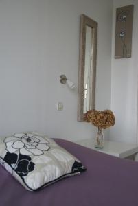 a bed with a pillow and a mirror in a room at Hôtel Des Deux Mers in Saint-Pierre-Quiberon