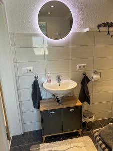ein Bad mit einem Waschbecken und einem Spiegel in der Unterkunft Gemütliche Ferienwohnung im Altbau in Goslar