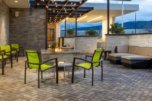 a patio with green chairs and a couch at SpringHill Suites by Marriott Pleasanton in Pleasanton