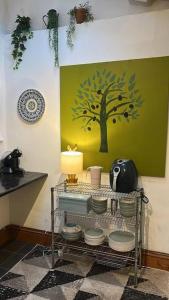 a kitchen with a plate rack with a tree painted on the wall at Just the Splott! Sleeps 6, 8 mins to Stadium. in Cardiff