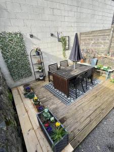 a wooden deck with a table and some plants at Just the Splott! Sleeps 6, 8 mins to Stadium. in Cardiff