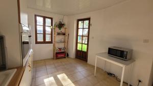 MontayralにあるDomaine des possibles - Equi Homeのテーブルの上に電子レンジがあり、ドアがあるキッチン