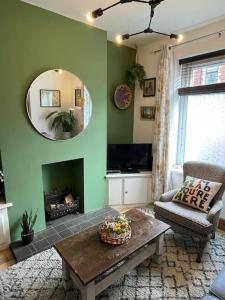 a living room with a table and a mirror at Just the Splott! Sleeps 6, 8 mins to Stadium. in Cardiff