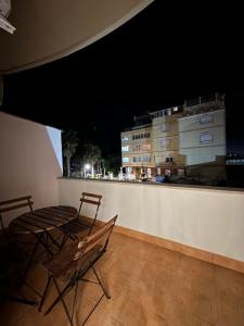 - deux chaises et une table sur un balcon la nuit dans l'établissement classy apartment Loui 2 Durres, à Durrës