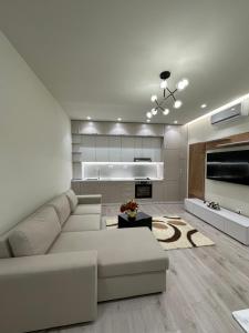 Il comprend un salon avec un canapé blanc et une cuisine. dans l'établissement classy apartment Loui 2 Durres, à Durrës