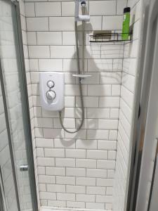 a white tiled bathroom with a shower and a toilet at Spacious Double Bedroom in Liverpool