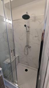a shower with a glass door in a bathroom at Couette et Tartine in Chalon-sur-Saône
