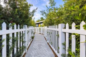 a white picket fence with a pathway at Stylish 2 BR condo - close to Riverwalk in Fort Lauderdale
