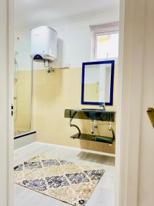 ein Bad mit einem Waschbecken und einem Spiegel in der Unterkunft Vans Haven in Curepipe