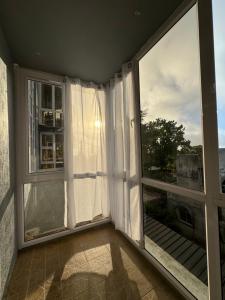 a room with a large window with white curtains at Vans Haven in Curepipe