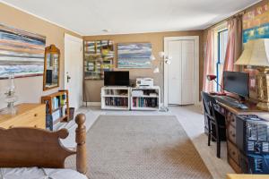 ein Wohnzimmer mit einem Bett und einem TV in der Unterkunft Serene Coastal Retreat home in Gouldsboro