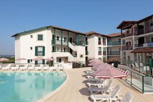 un hôtel avec une piscine, des chaises et des parasols dans l'établissement Appartement entre mer et montagne, à Arcangues