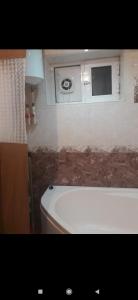 uma casa de banho com uma banheira e uma janela em Квартира em Samarkand