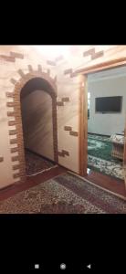uma porta para um quarto com uma lareira de tijolos em Квартира em Samarkand