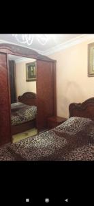 - une chambre avec 2 lits et un grand miroir dans l'établissement Квартира, à Samarcande