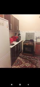 uma pequena cozinha com fogão e tapete em Квартира em Samarkand
