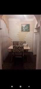 uma mesa e cadeira num quarto com uma parede de tijolos em Квартира em Samarkand