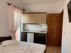 Un dormitorio con una cama y una pequeña cocina. en Vila Florand Sela, en Ksamil