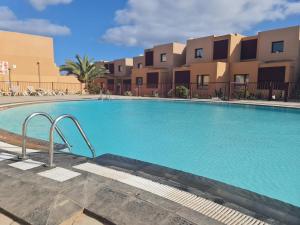 a large swimming pool in front of some apartments at BAHIA AZUL in Caleta De Fuste
