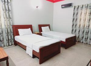 2 camas en una habitación con en Rose Palace Guest House en Karachi