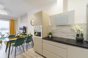 Lumina 2-room apartments with parking Lodz في لودز: مطبخ مع طاولة وغرفة طعام