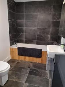 a bathroom with a tub and a toilet and a sink at Wild Atlantic Seaside Cottage in Easkey +8 photos