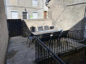 a table and chairs on a balcony with a building at Maison de ville des Bernardines in Orgelet