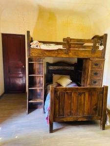 a wooden bunk bed in a room with a book shelf at Casa Santuario in Antigua Guatemala
