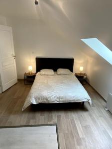 1 dormitorio con 1 cama con 2 mesitas de noche y 2 lámparas en Maison de ville des Bernardines, en Orgelet