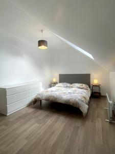 - une chambre blanche avec un lit dans l'établissement Maison de ville des Bernardines, à Orgelet
