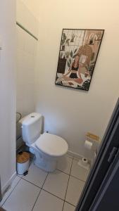 La salle de bains est pourvue de toilettes et d'une photo murale. dans l'établissement Couette et Tartine, à Chalon-sur-Saône