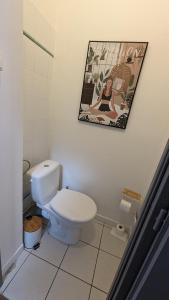 a bathroom with a toilet and a picture on the wall at Couette et Tartine in Chalon-sur-Saône +31 photos