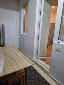 Il comprend une cuisine équipée d'une table en bois et d'un réfrigérateur. dans l'établissement Cazare Regim Hotelier apartament 2 camere Militari, à Roşu