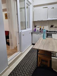 une cuisine avec des placards blancs et un comptoir dans l'établissement Cazare Regim Hotelier apartament 2 camere Militari, à Roşu